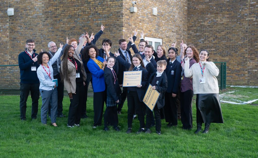 Radcliffe School solar education day group pointing to the solar on the roof